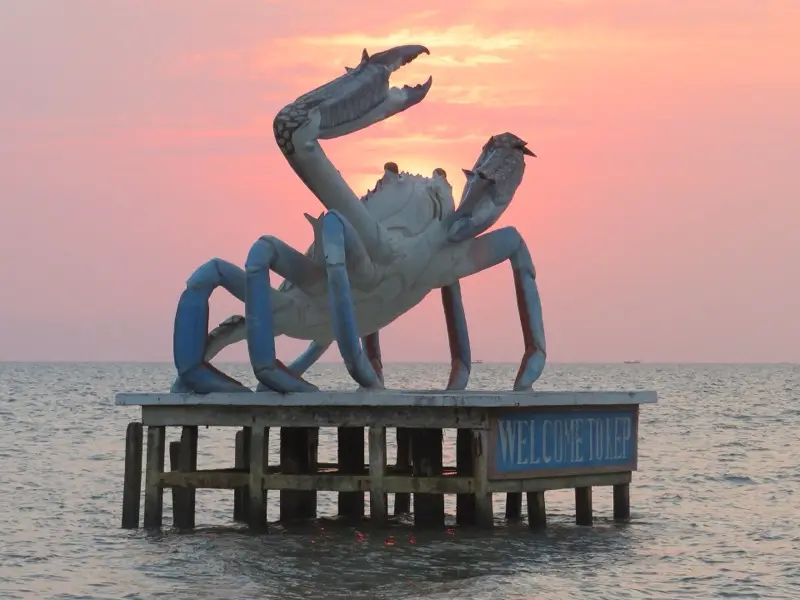 The crab statue in the sea at Kep at sunset